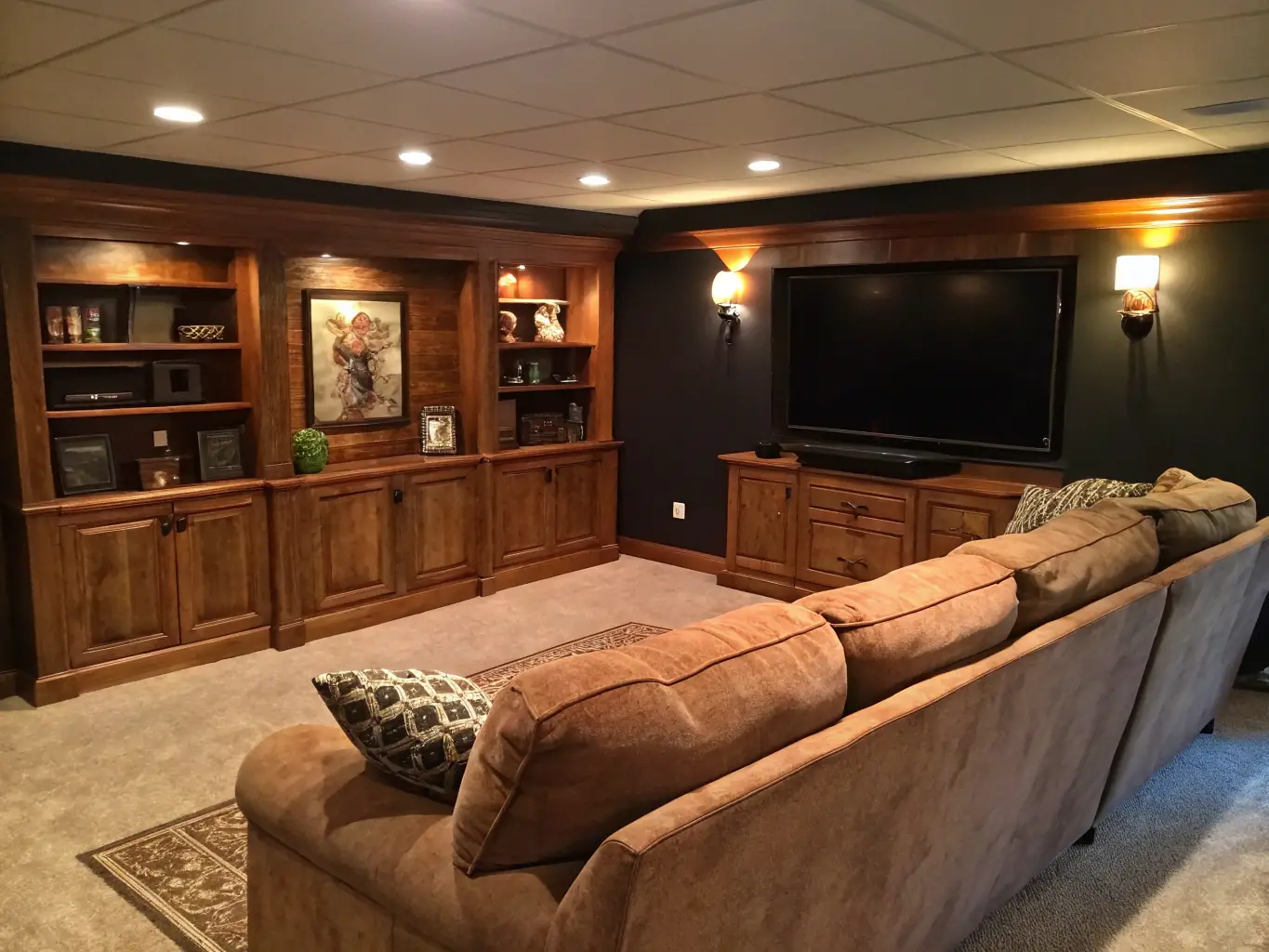 A finished basement with a home theater setup, comfortable seating, and custom lighting, demonstrating SwiftBuild Pros™'s ability to create inviting basement living spaces.